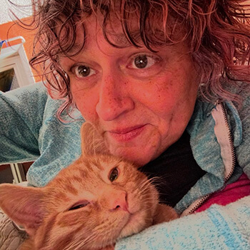 Kitty sitter snuggling her orange kitty.